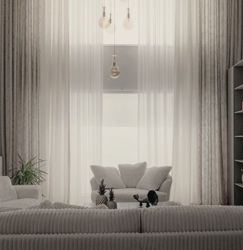 Helles Wohnzimmer mit Sofa und hohen Vorhängen